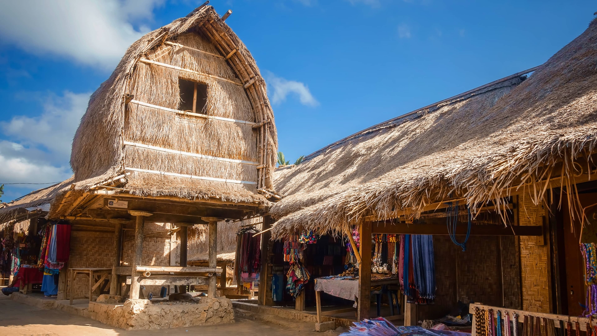 Traditional thatched-roof houses and craft stalls in Sade village, Lombok